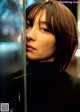 A woman with short hair looking out of a window.