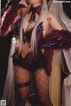 A woman in a black and purple outfit posing for a picture.