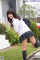 A young woman in a school uniform is posing for the camera.