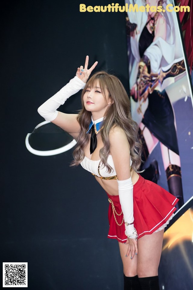 A woman in a red and white outfit posing for a picture.