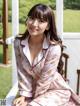 A woman in a pink pajamas sitting on a porch.