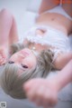 A woman laying on a bed in a white lingerie.